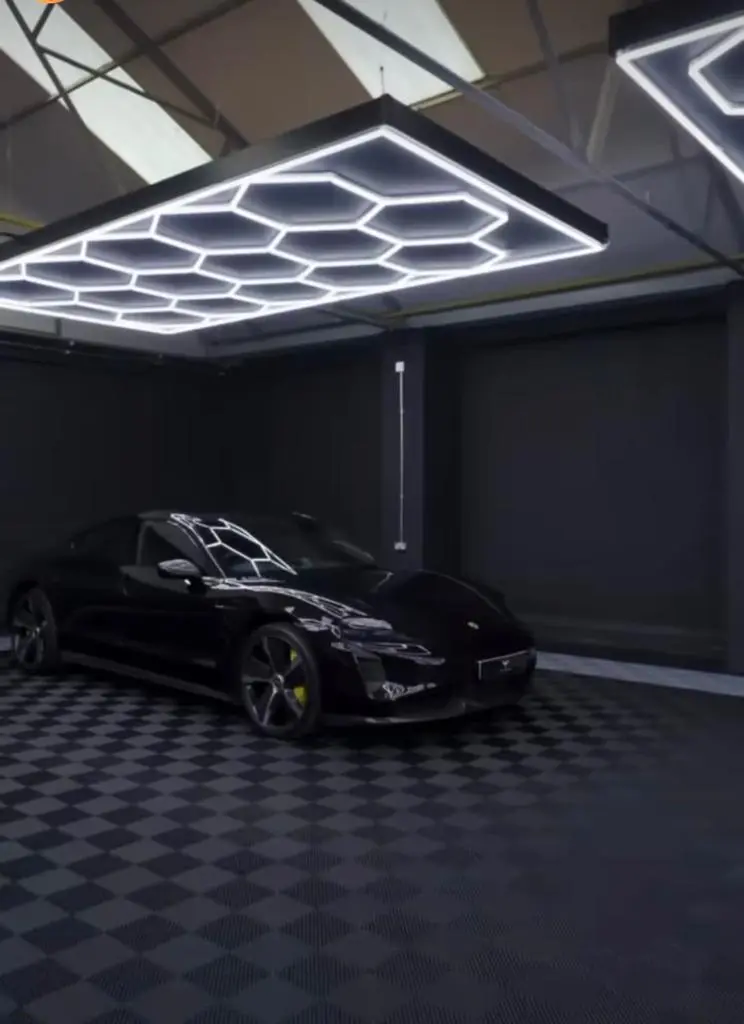 Must sportauto musta värvi põrandal, mis moodustatud Tuff-Tile põrandaplaatidest ja valgustatud Tuff-Lite suure, Hex15 LED valgustiga. 