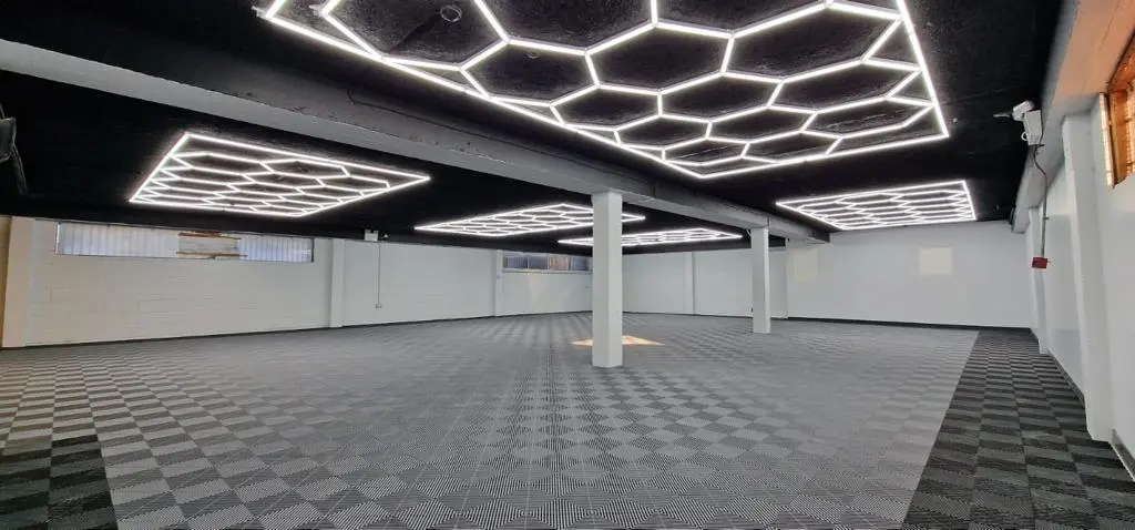 Suur ruum kaetud hallide tuff-tile plaatidega ja valgustatud laes olevate HEX15 LED valgustitega.