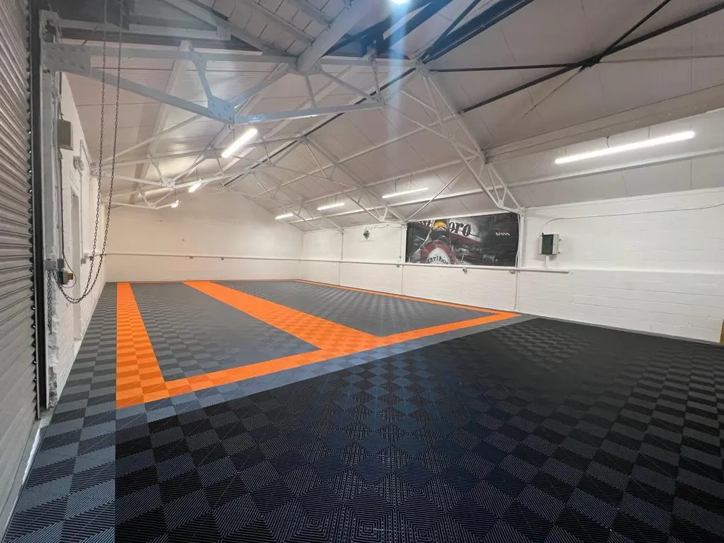 A big garage flooring covered with tuff-tile floor tiles in black and orange